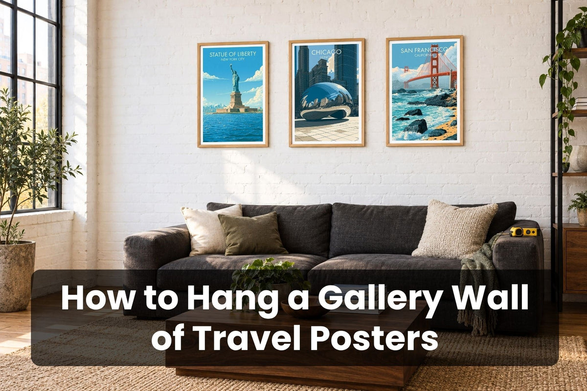 Gallery wall of three travel posters in oak frames above a charcoal sofa: Statue of Liberty New York, Cloud Gate Chicago and Golden Gate Bridge San Francisco, with the title How to Hang a Gallery Wall of Travel Posters