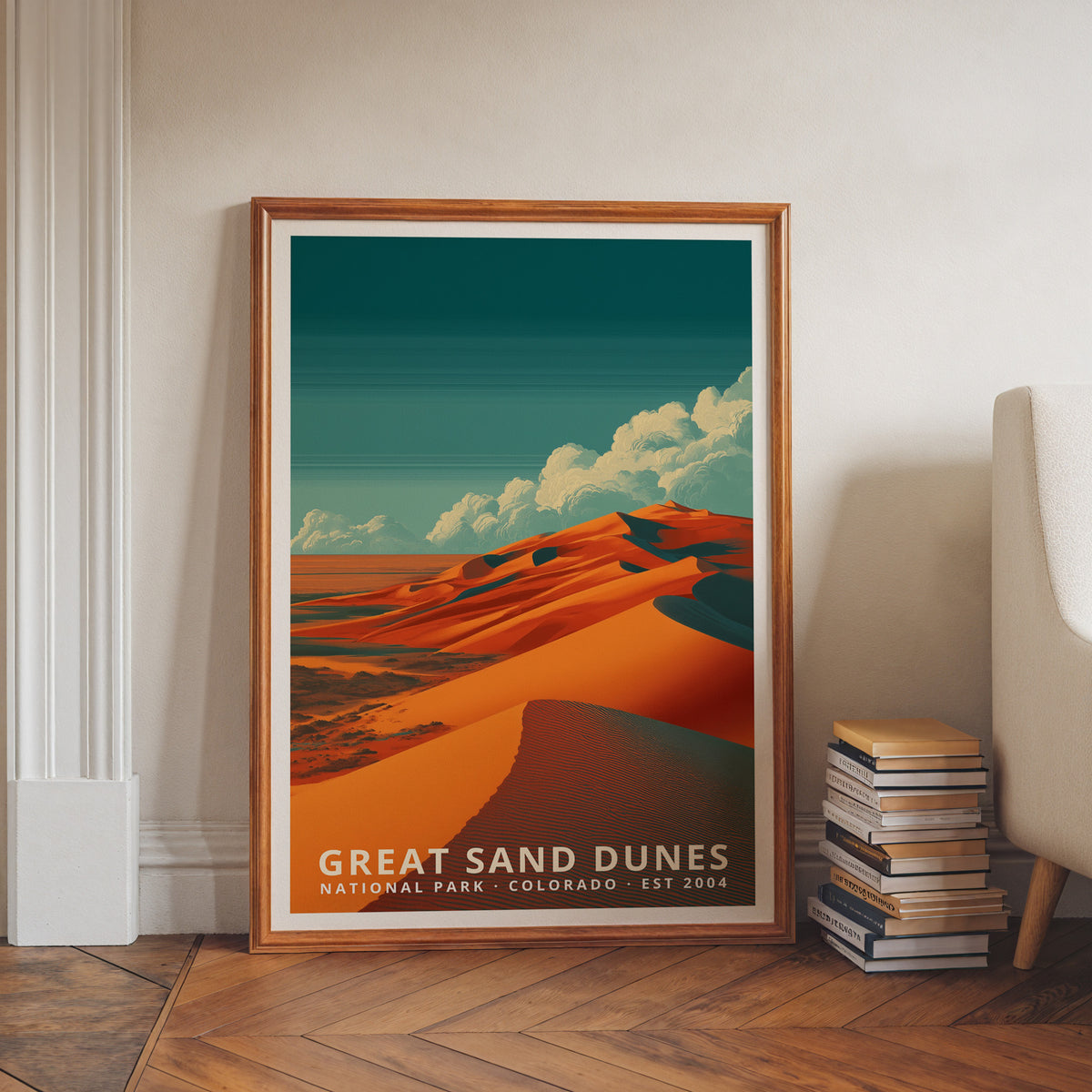 Great Sand Dunes National Park retro travel poster in a wood frame, leaning against a wall beside books and an armchair