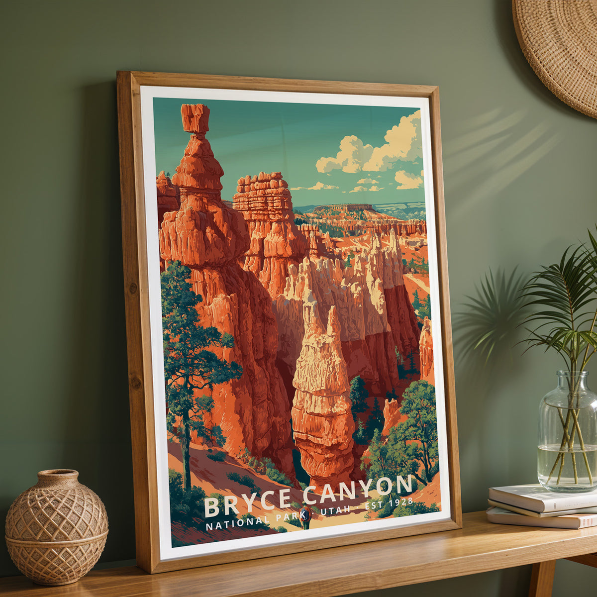 Framed Bryce Canyon National Park retro print on a wooden sideboard against a sage green wall with vases and books