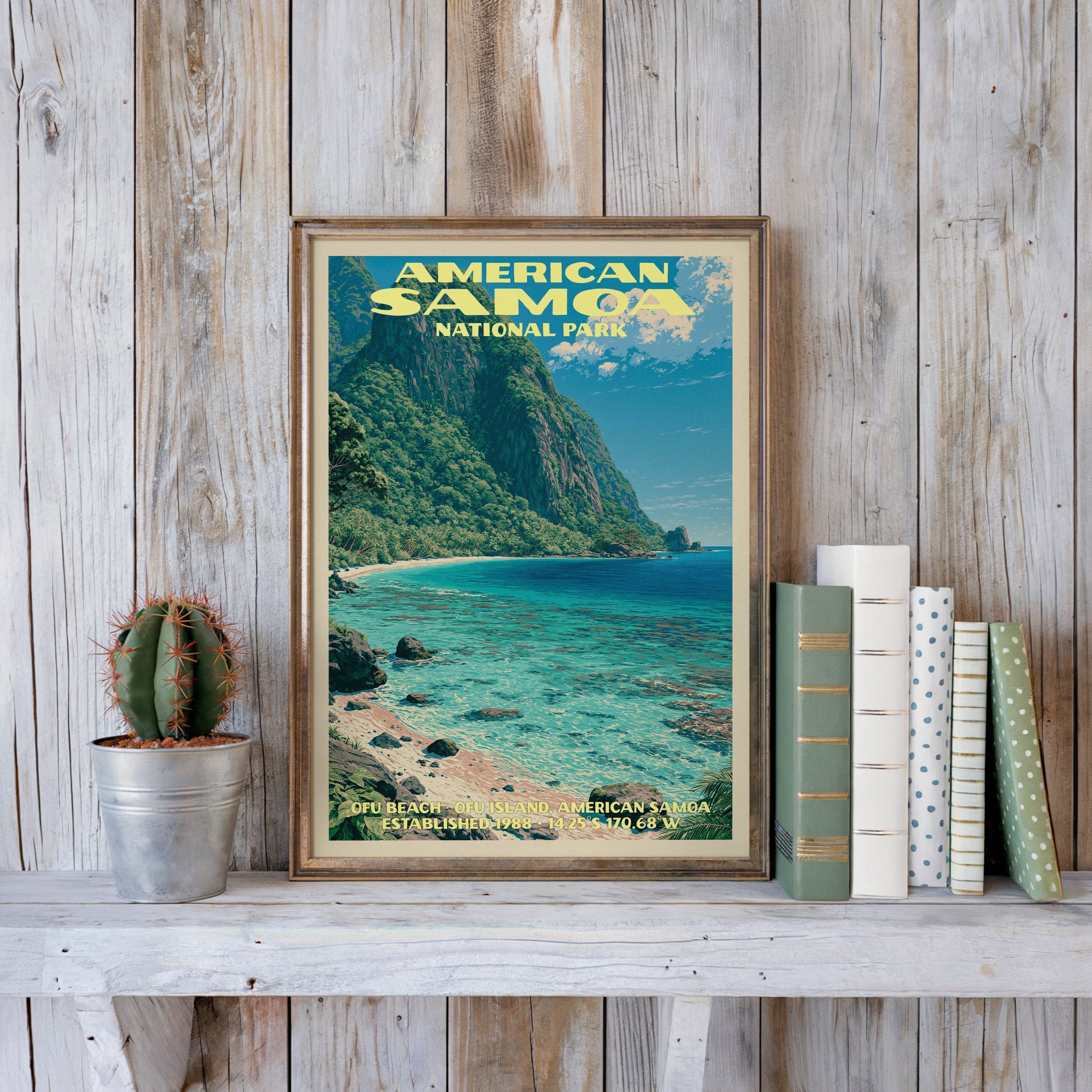 American Samoa vintage poster in a slim gold frame on a whitewashed plank wall beside a cactus and pastel books