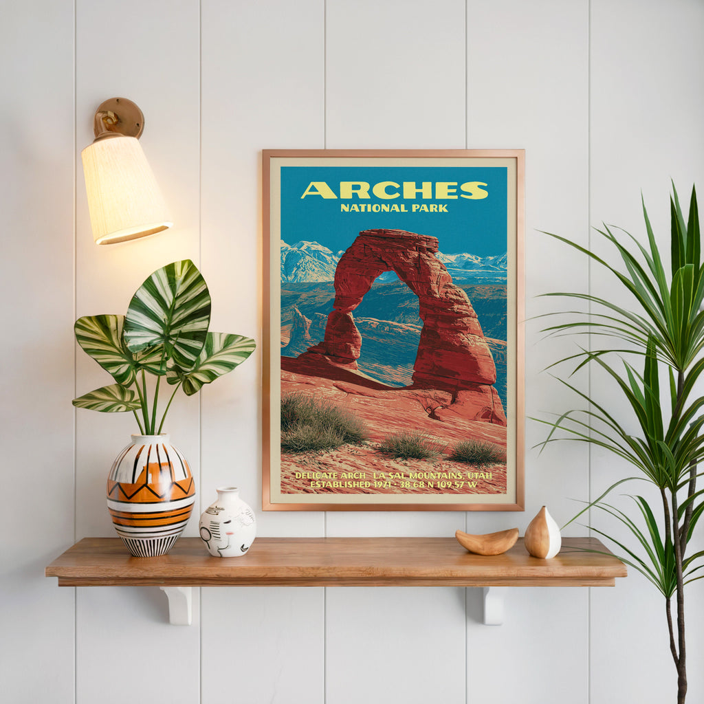 Delicate Arch Arches print framed on white panelling above an oak shelf with a patterned vase and sconce
