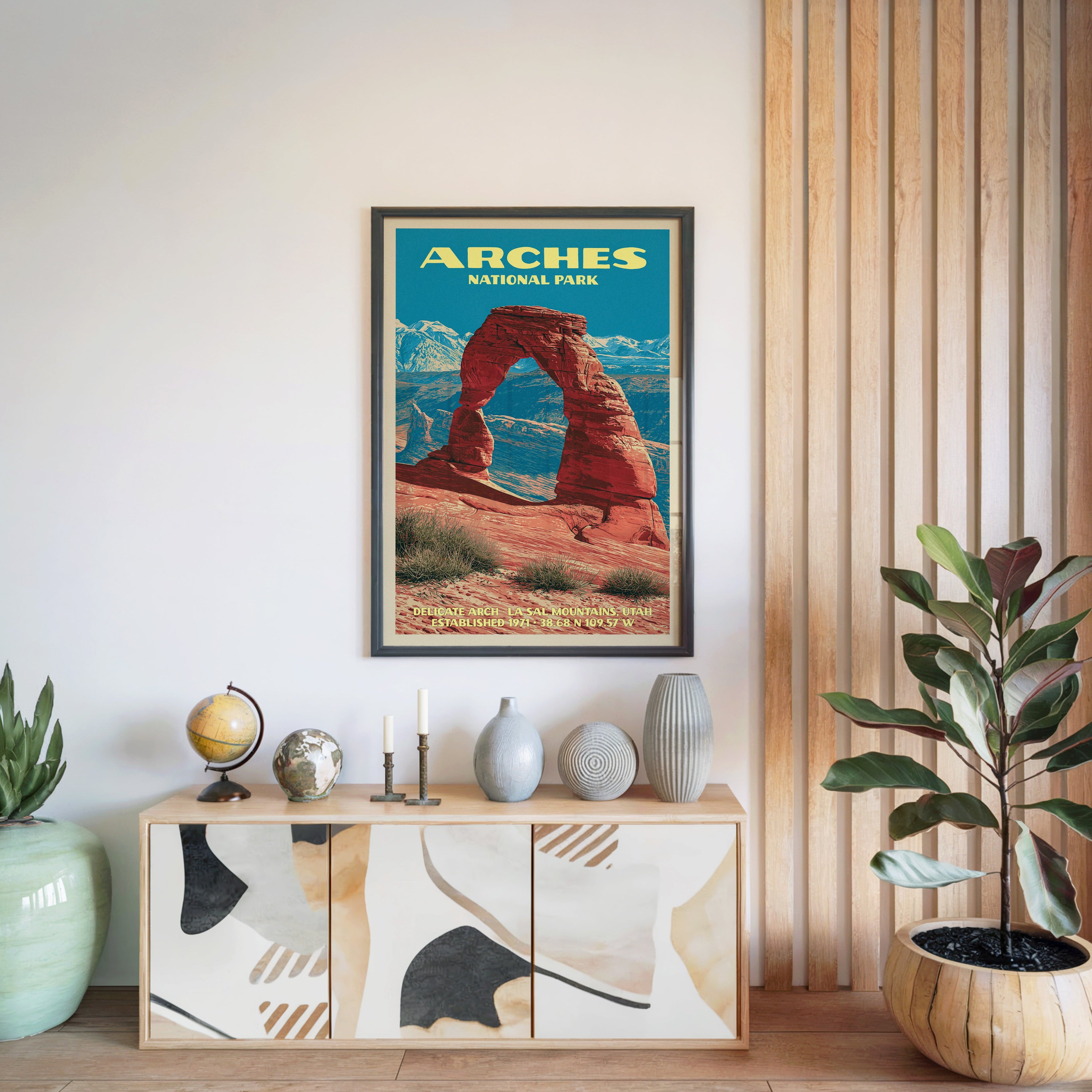Arches National Park poster in a black frame above a light wood sideboard by a slatted wall panel