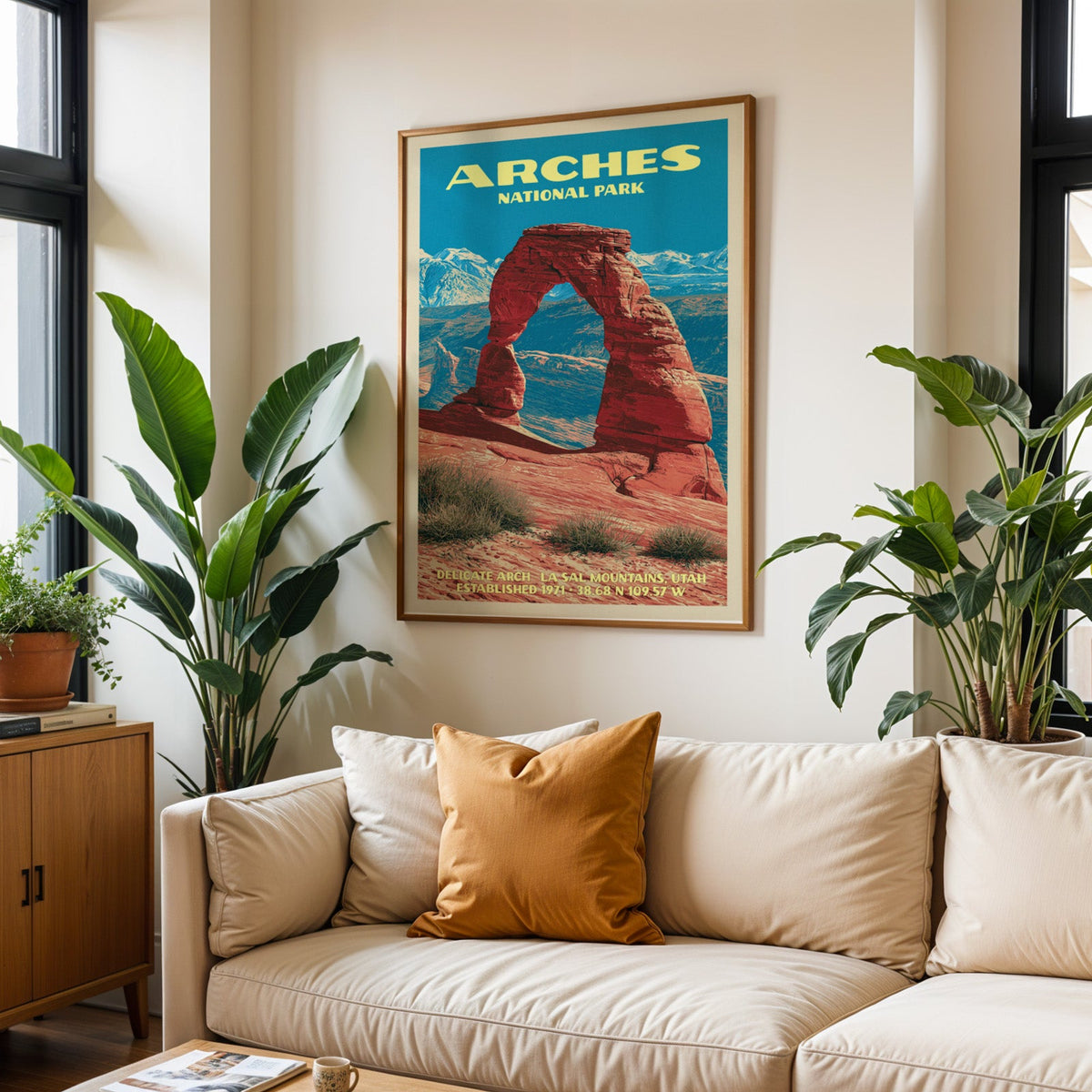 Arches vintage travel print in oak above a cream sofa with a rust cushion and tall houseplants