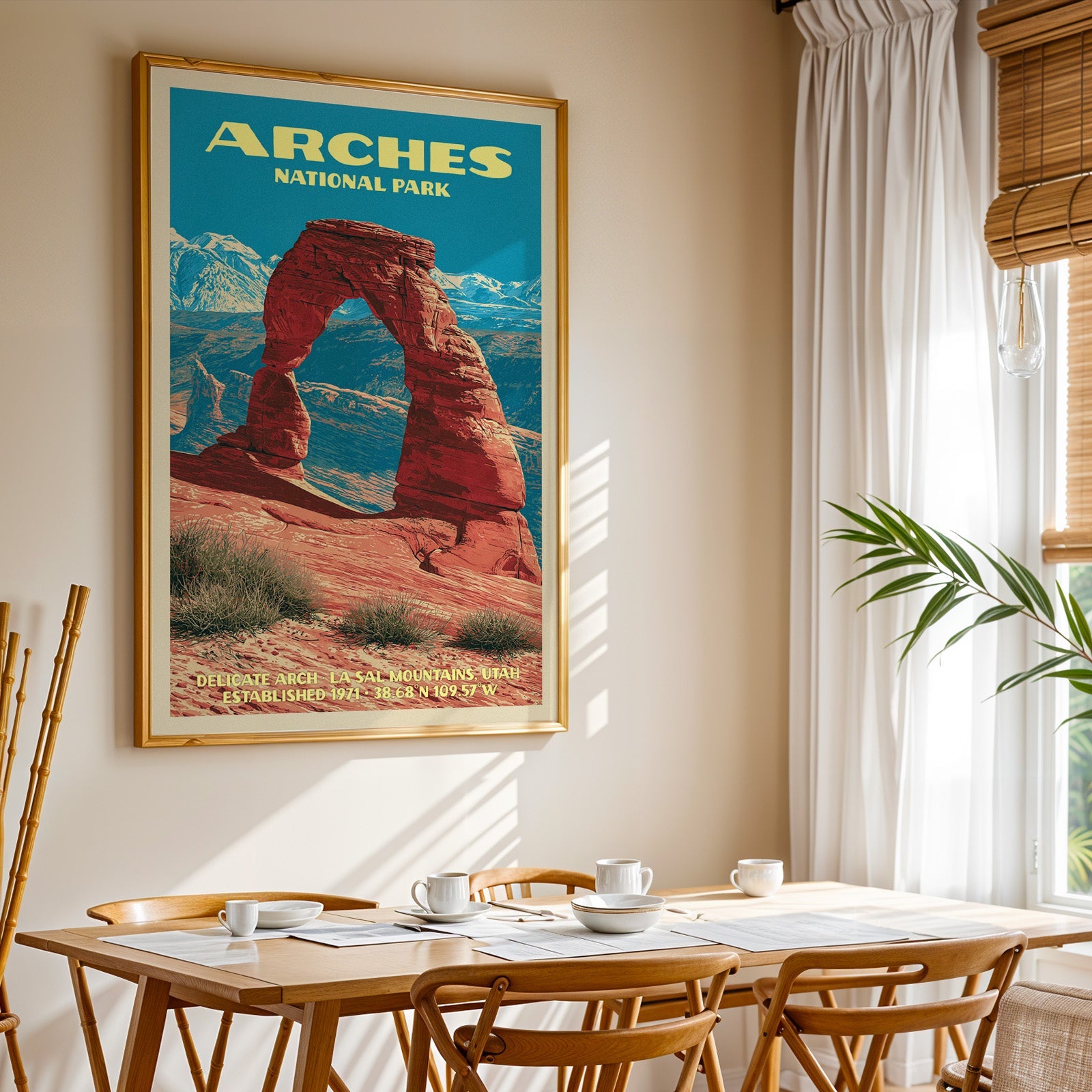 Arches National Park print in gold above a light oak dining table by a curtained window