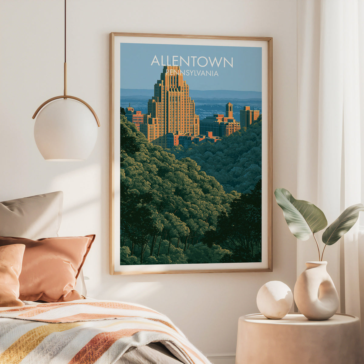 Lehigh Valley skyline poster in a large oak frame above a bed with rust bedding and a brass pendant light.