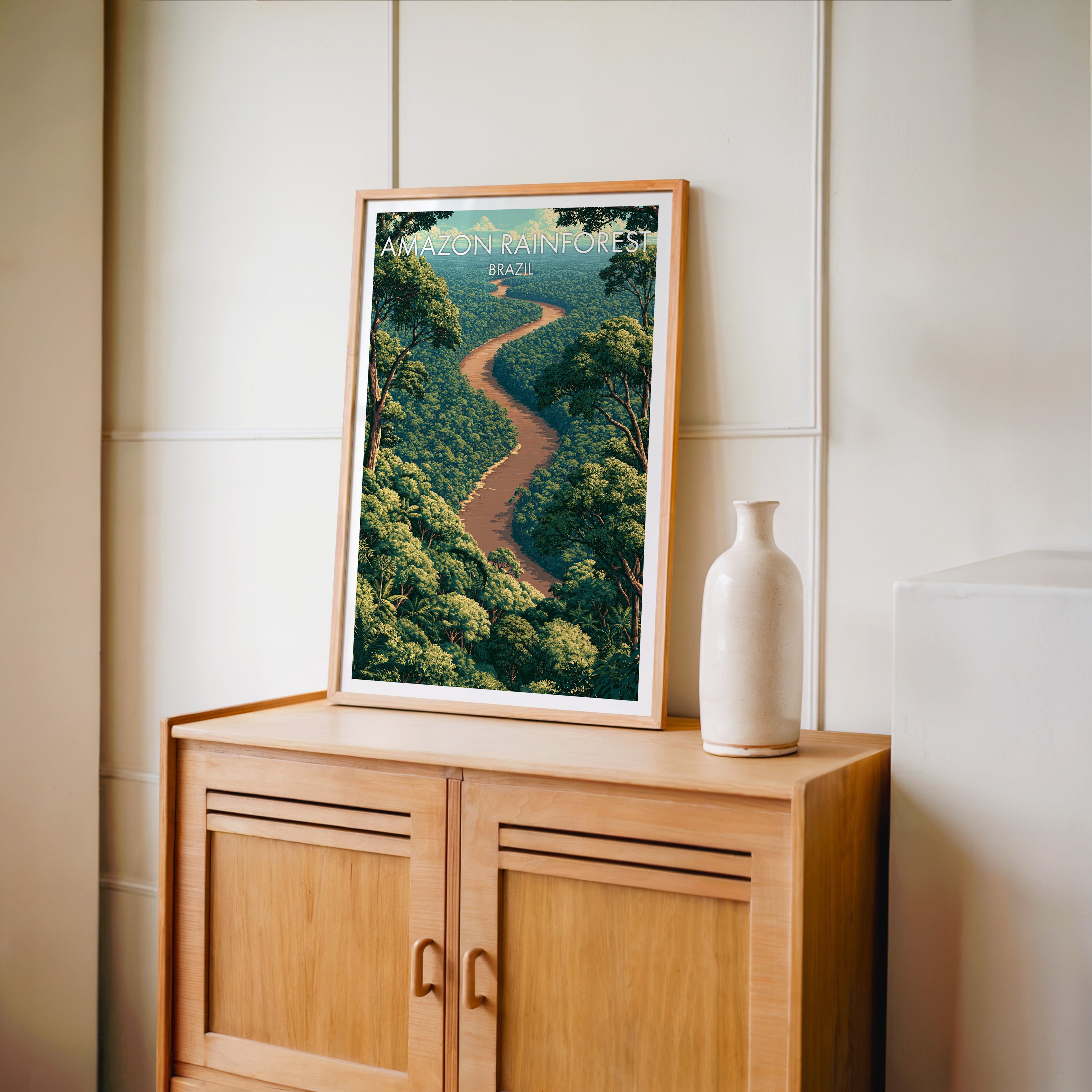 Amazon canopy wall art in an oak frame on a light oak cabinet against cream panelled walls