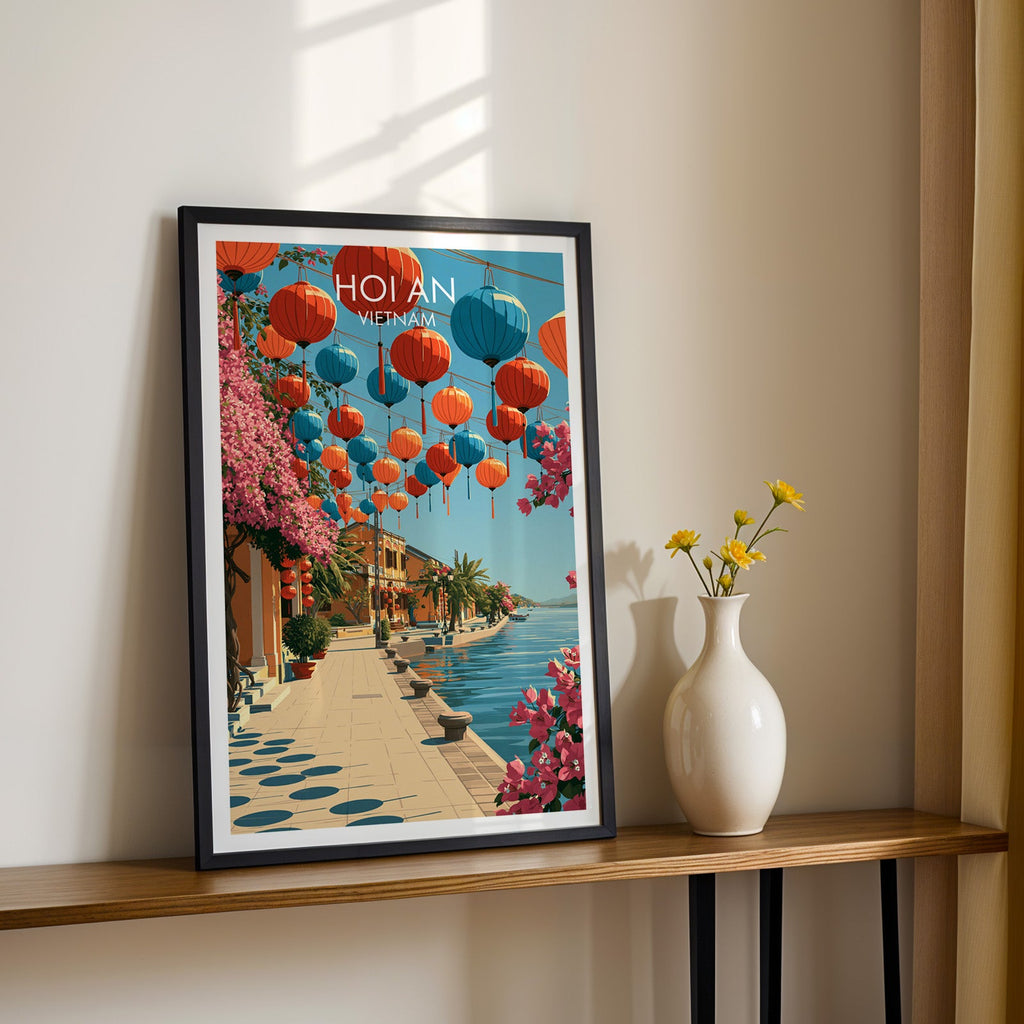 Black framed Hoi An lantern print on a narrow hallway console in sunlight, styled with yellow flowers