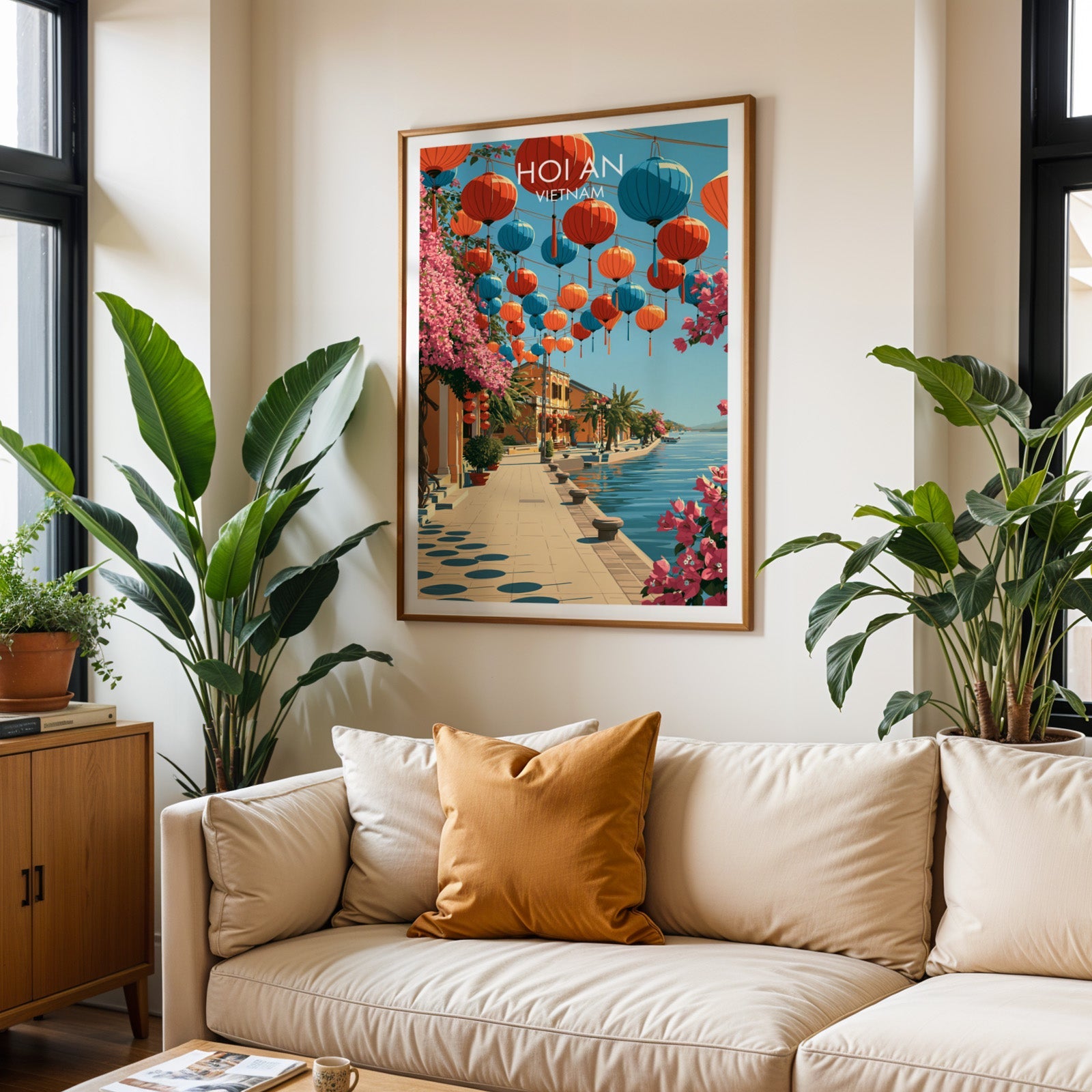 Framed Hoi An Vietnam wall art hanging above a cream sofa in a bright living room with tropical plants