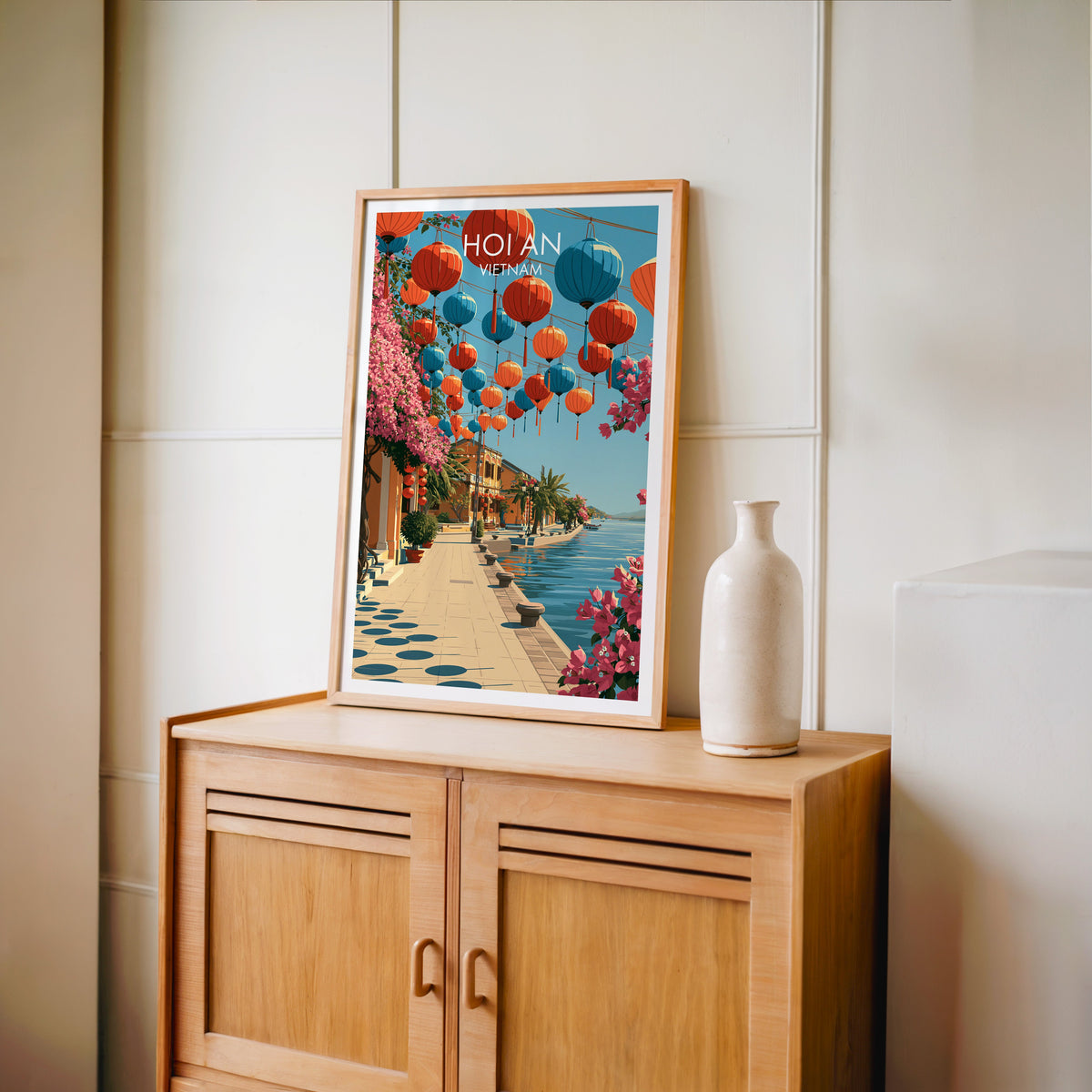 Hoi An Vietnam travel poster in an oak frame standing on a light oak cabinet against a cream panelled wall