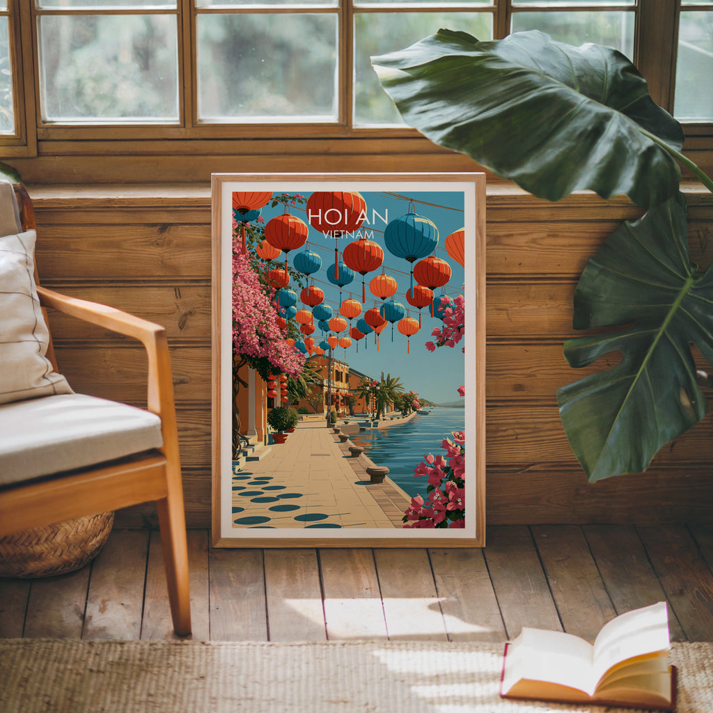 Framed Hoi An Vietnam poster leaning against a timber cabin wall with monstera leaves and an open book