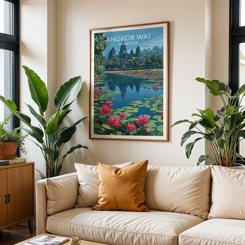 Framed Angkor Wat Cambodia wall art hanging above a cream sofa in a bright living room with tropical plants