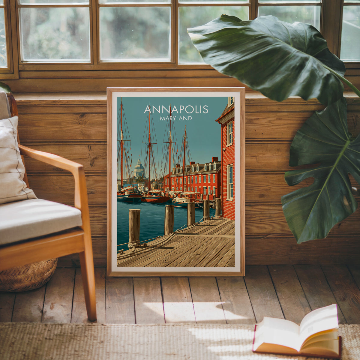 Chesapeake sailboat print in an oak frame on a sunlit panelled wall beside a mid-century armchair