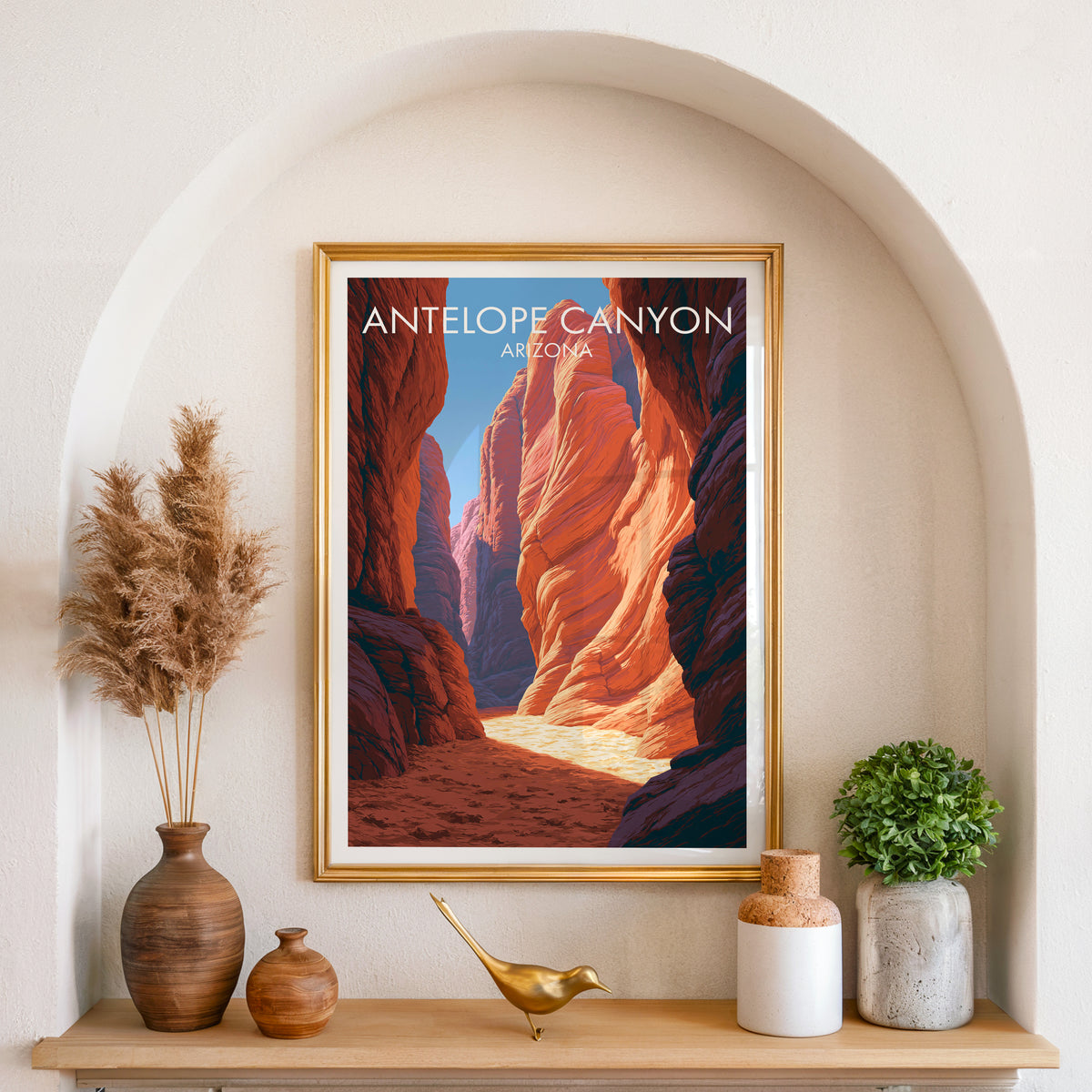 Antelope Canyon poster in a gold frame set in an arched wall niche with pampas grass and a brass bird
