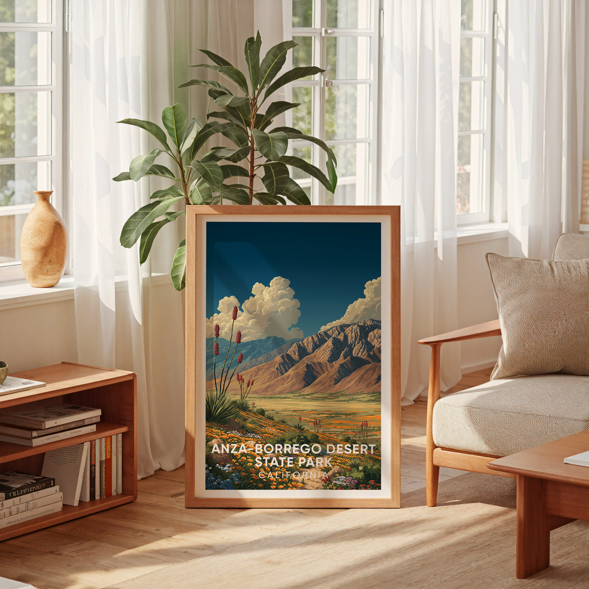 Anza-Borrego bloom print leaning at a tall sheer-curtained window with a rubber plant, low bookshelf and cream armchair