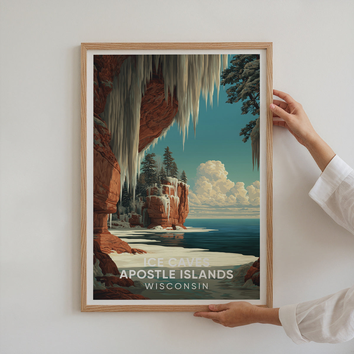 Two hands holding an oak-framed Apostle Islands ice caves poster against a white wall