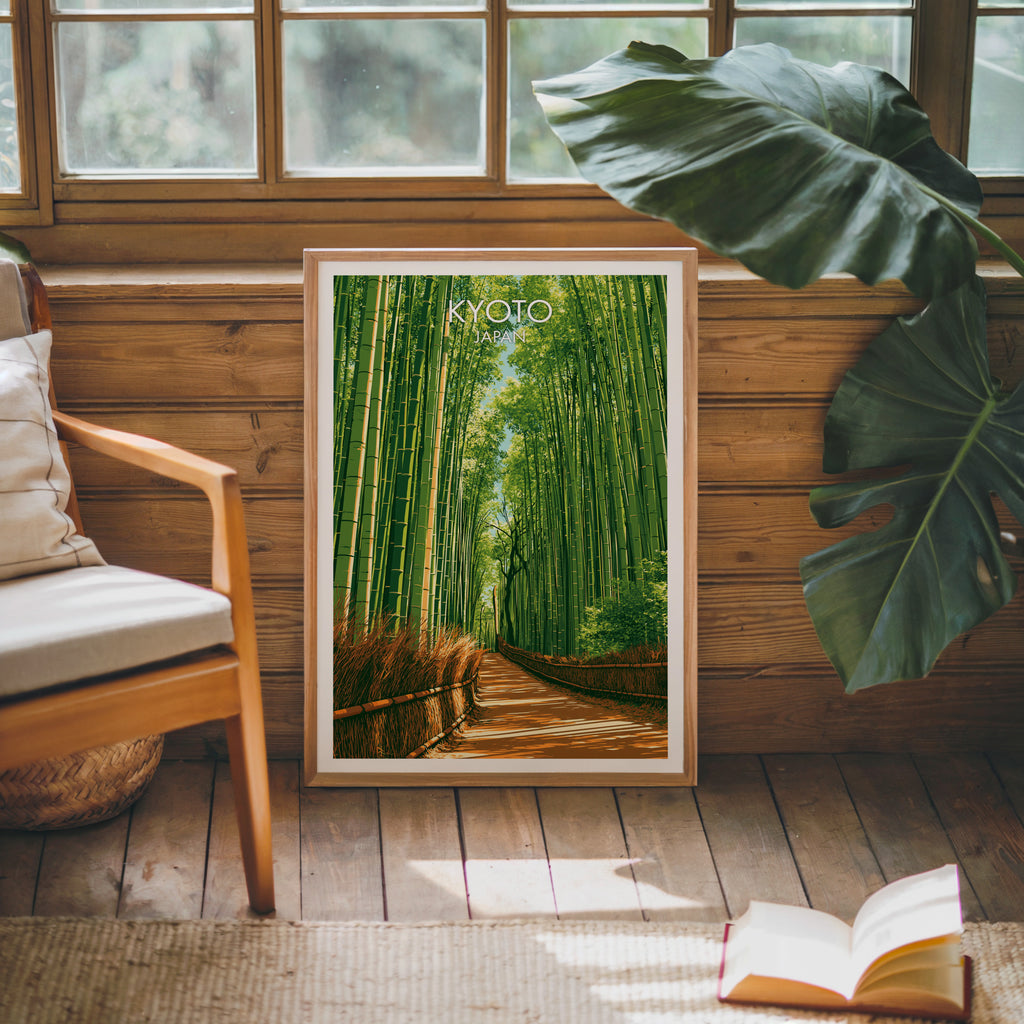 Framed Arashiyama Bamboo Forest Kyoto poster leaning against a timber cabin wall with monstera leaves and an open book