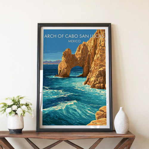 Golden sea arch artwork in a black frame on a walnut console with white peonies and a ceramic vase