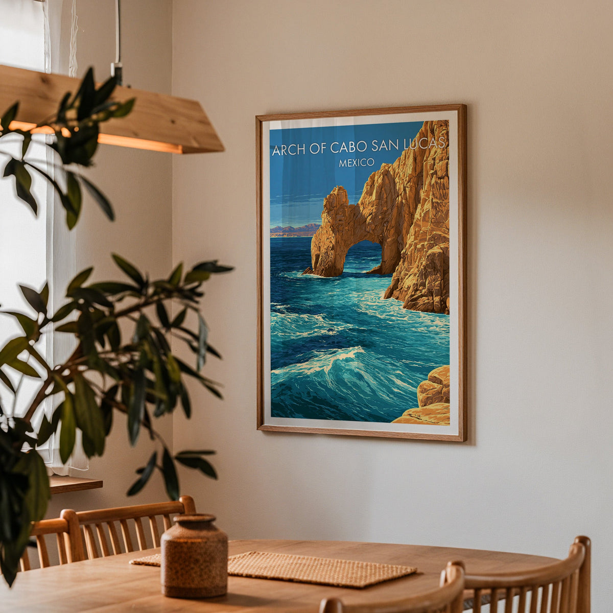 Sea arch poster in an oak frame in a dining corner with an oak table, spindle chairs and pendant lamp