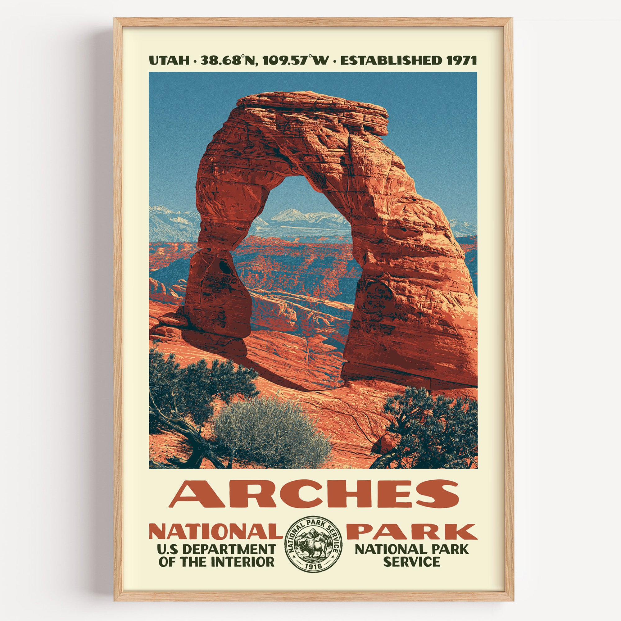 Arches National Park vintage WPA poster in a wood frame, Delicate Arch glowing rust-orange with the La Sal Mountains behind