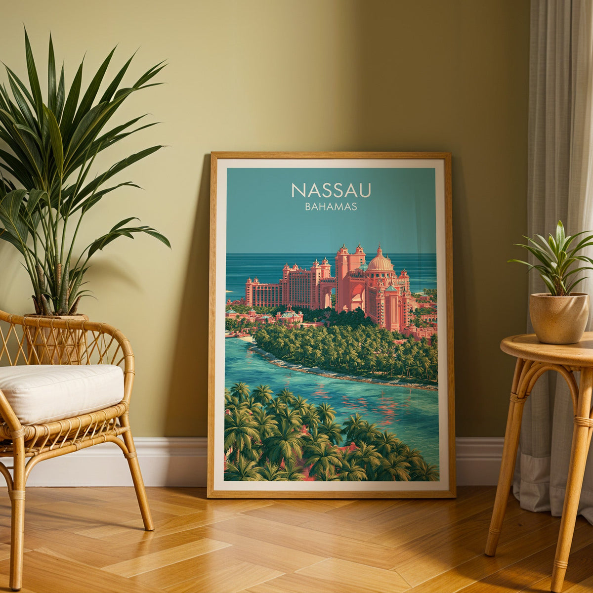Aerial island print in an oak frame on herringbone parquet, olive wall, rattan chair and cane side table