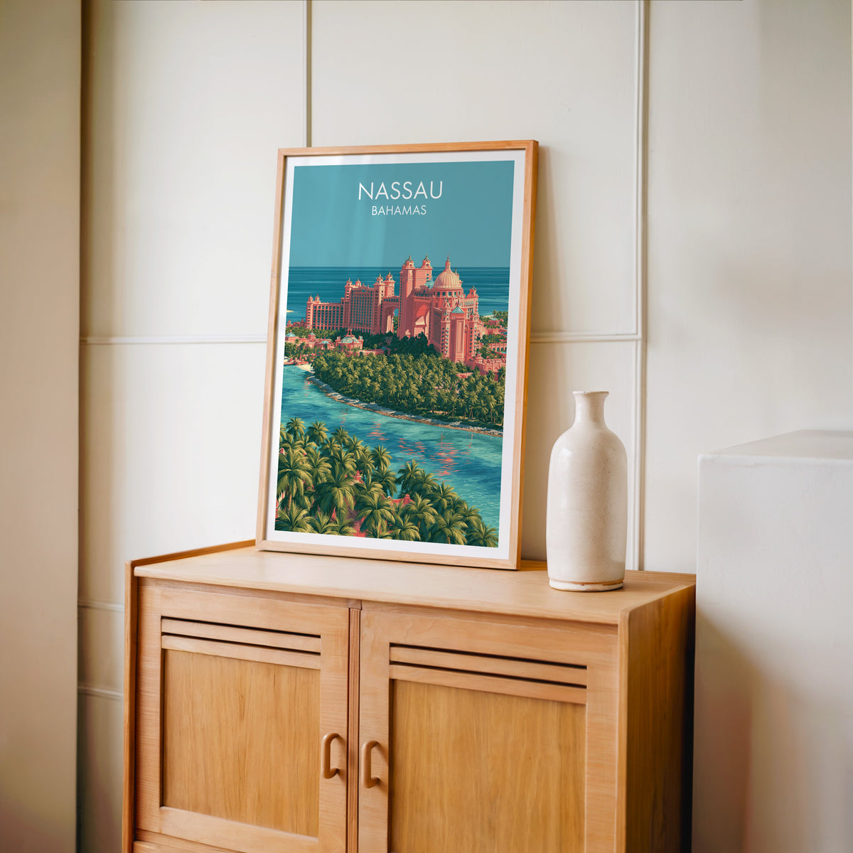 Palm-fringed sand spit in an oak frame on a light oak cabinet against a cream panelled wall