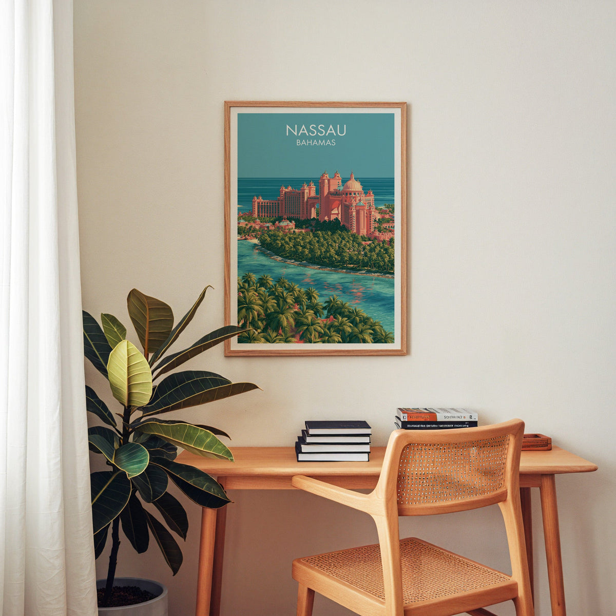Bahamas island artwork in an oak frame above a wooden desk with a cane chair and a rubber plant