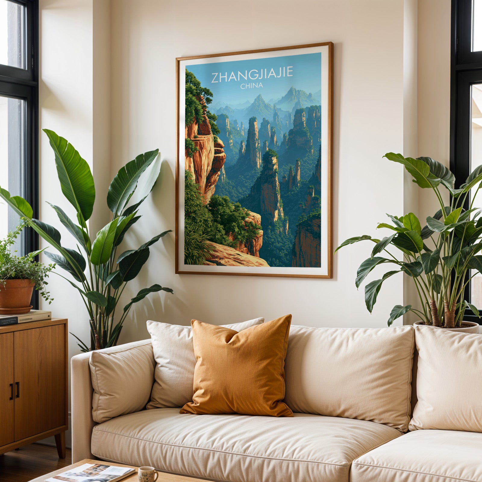Framed Zhangjiajie China wall art hanging above a cream sofa in a bright living room with tropical plants