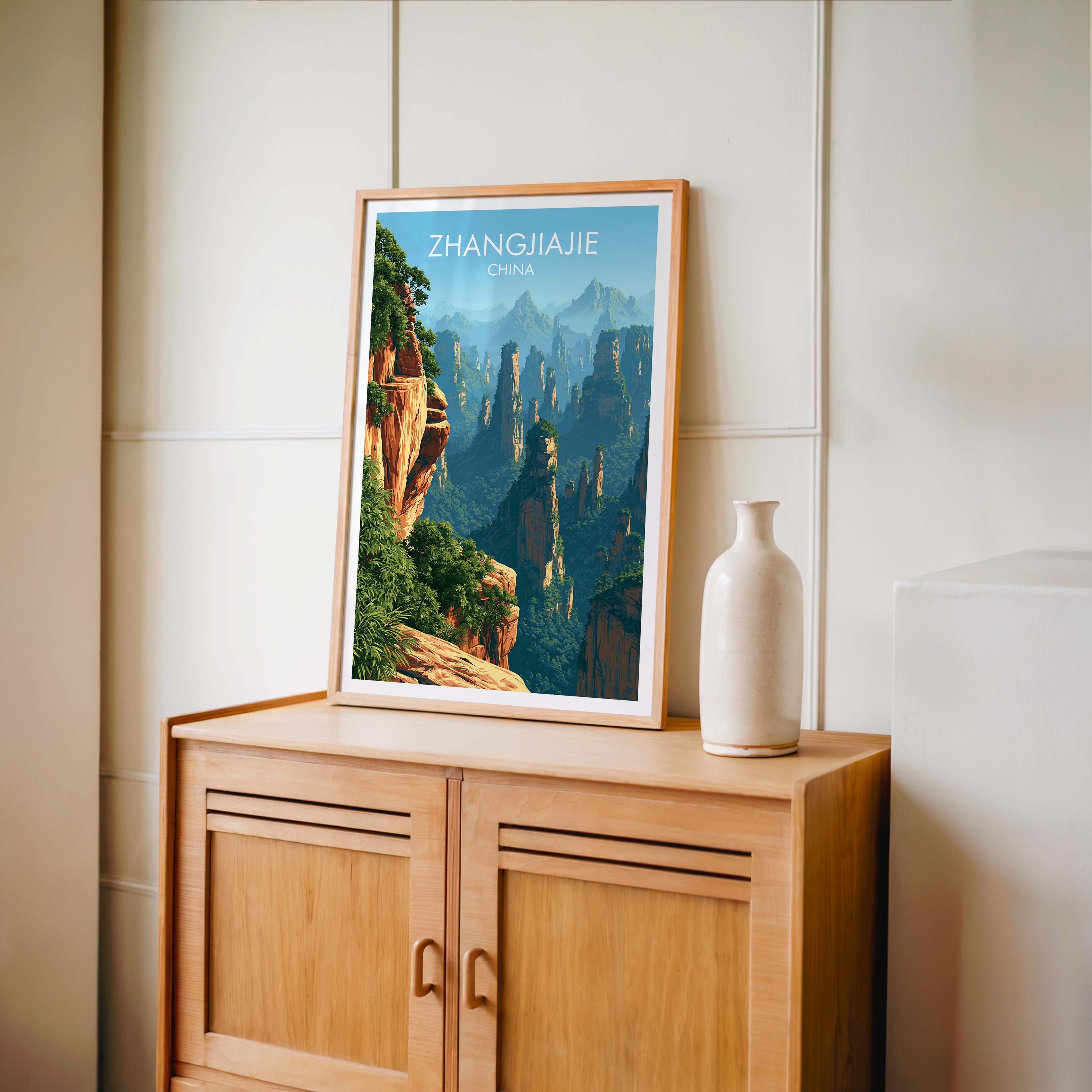 Small Zhangjiajie China travel poster in an oak frame on a mid-century sideboard with a ceramic vase