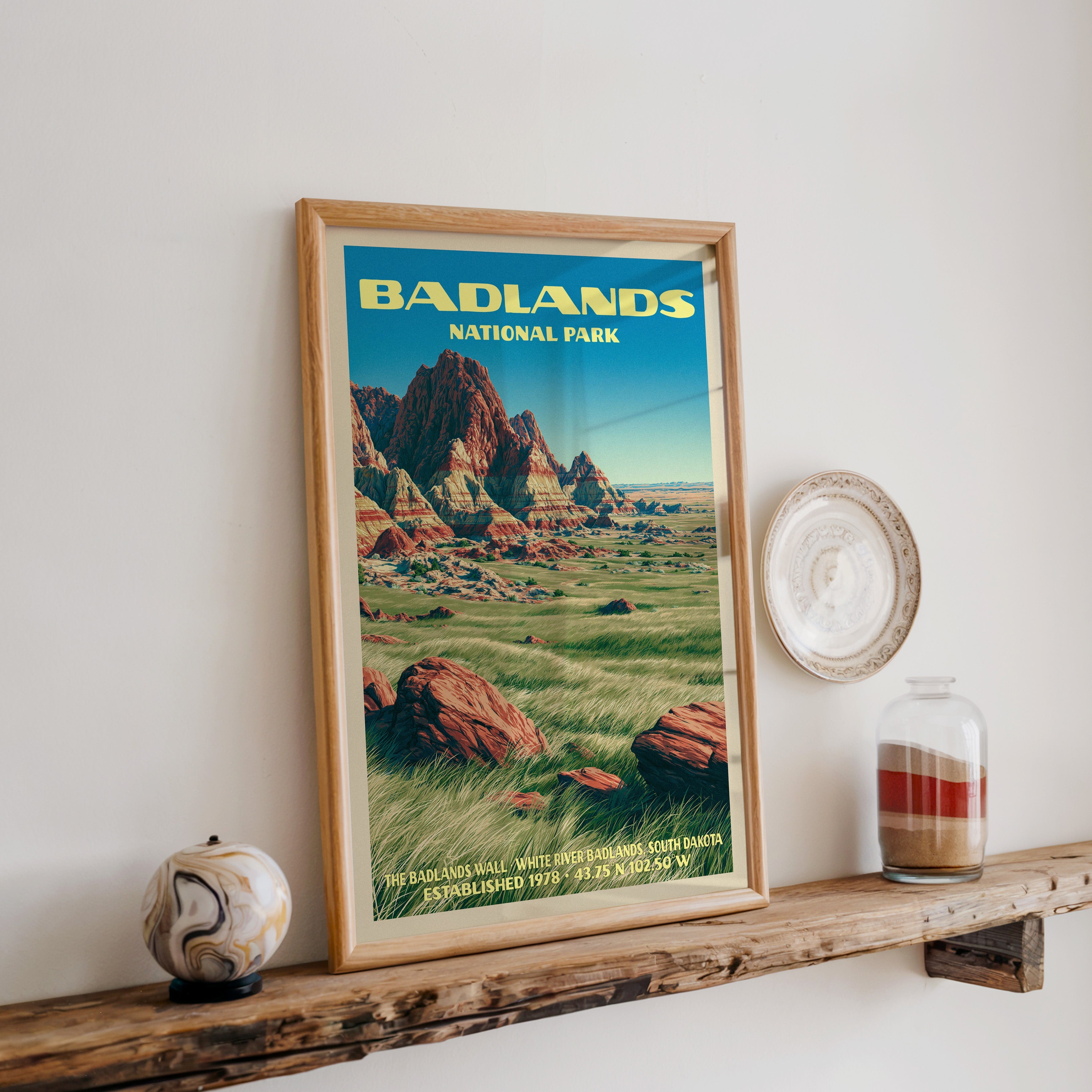 Badlands Wall print in oak, leaning on a reclaimed wood ledge with a marbled sphere and a sand jar