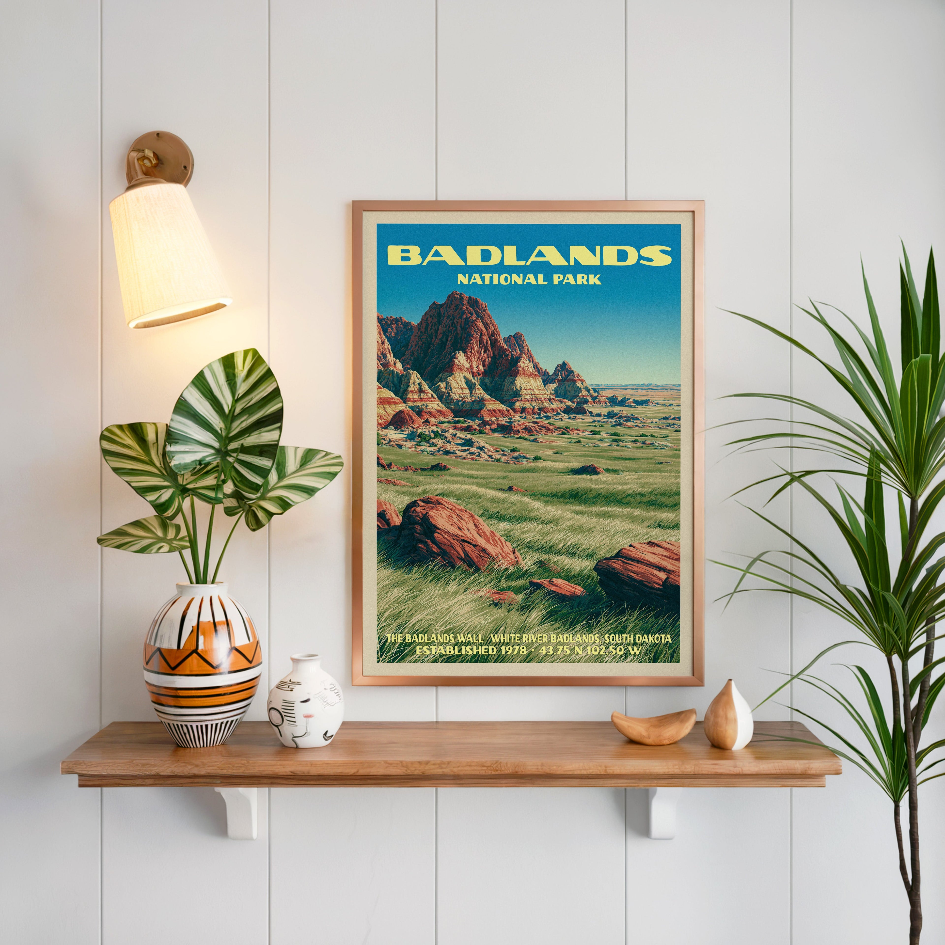 Badlands Wall print framed on white panelling above an oak shelf with a patterned vase and a sconce