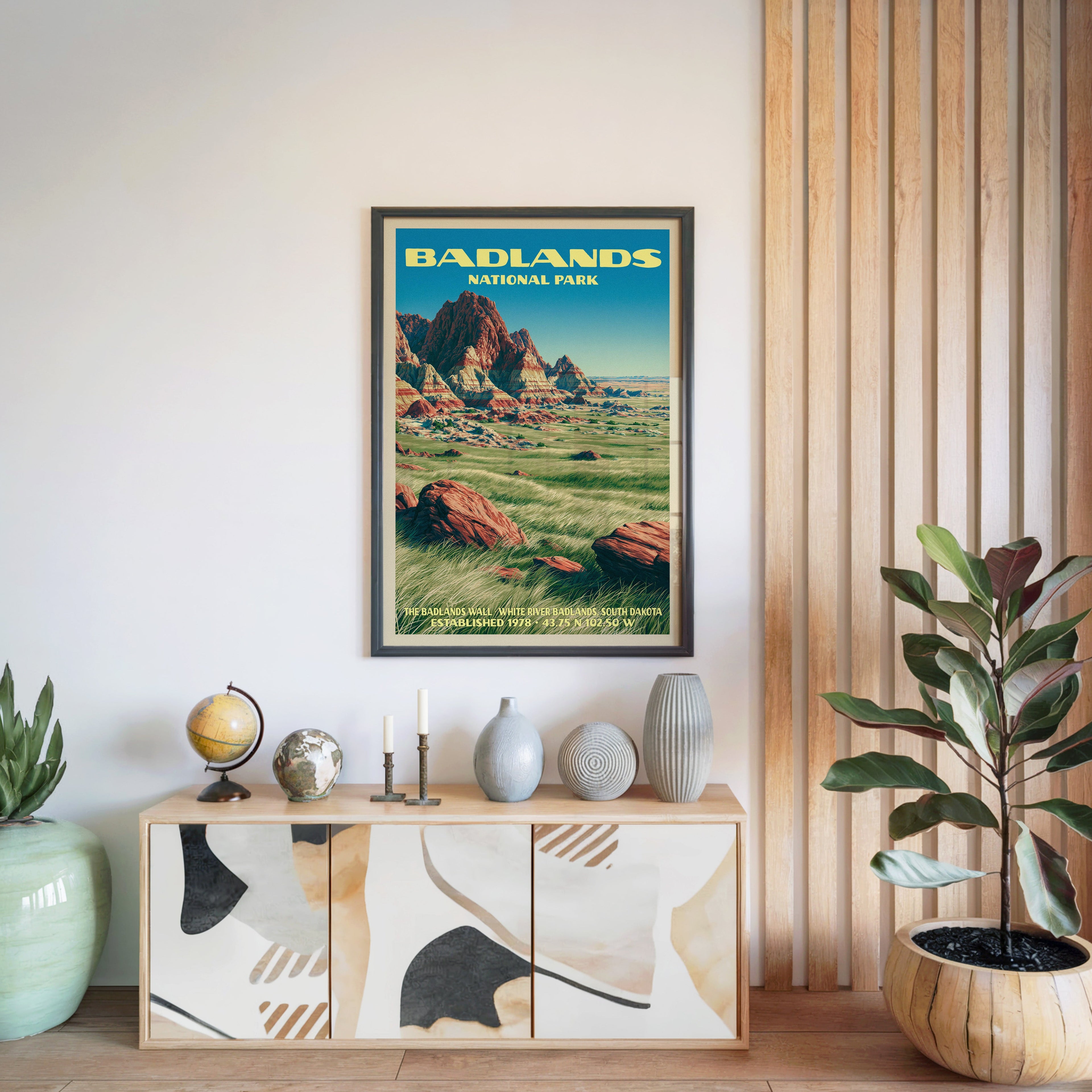 Badlands National Park poster in a black frame above a light wood sideboard by a slatted wall panel