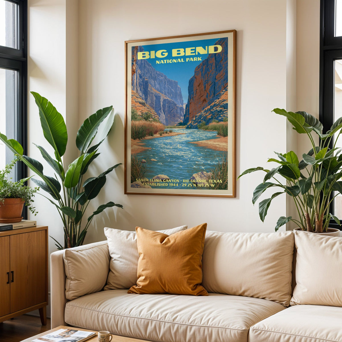 Big Bend vintage travel print in oak above a cream sofa with a rust cushion and tall houseplants