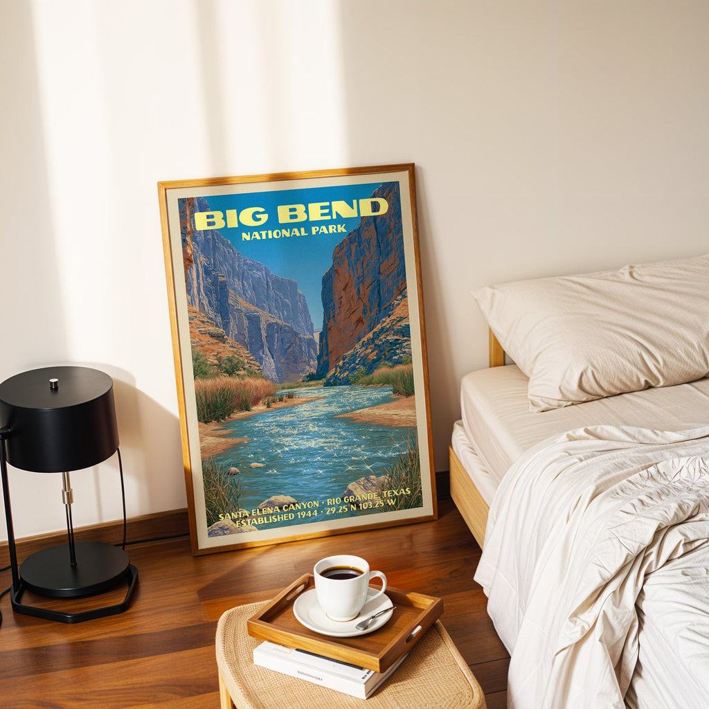 Santa Elena Canyon Big Bend poster in a gold frame on the floor beside a made bed and a black table lamp