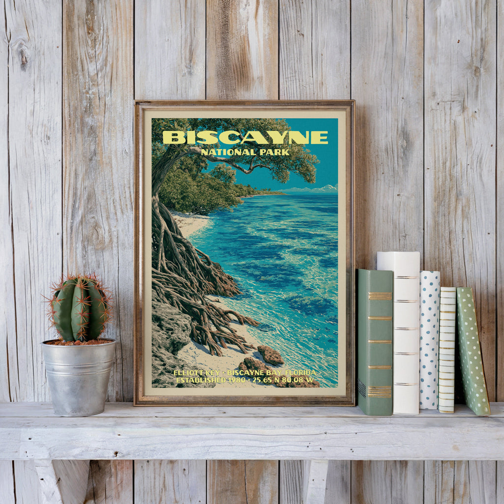 Biscayne vintage poster in a slim gold frame on a whitewashed plank wall beside a cactus and pastel books