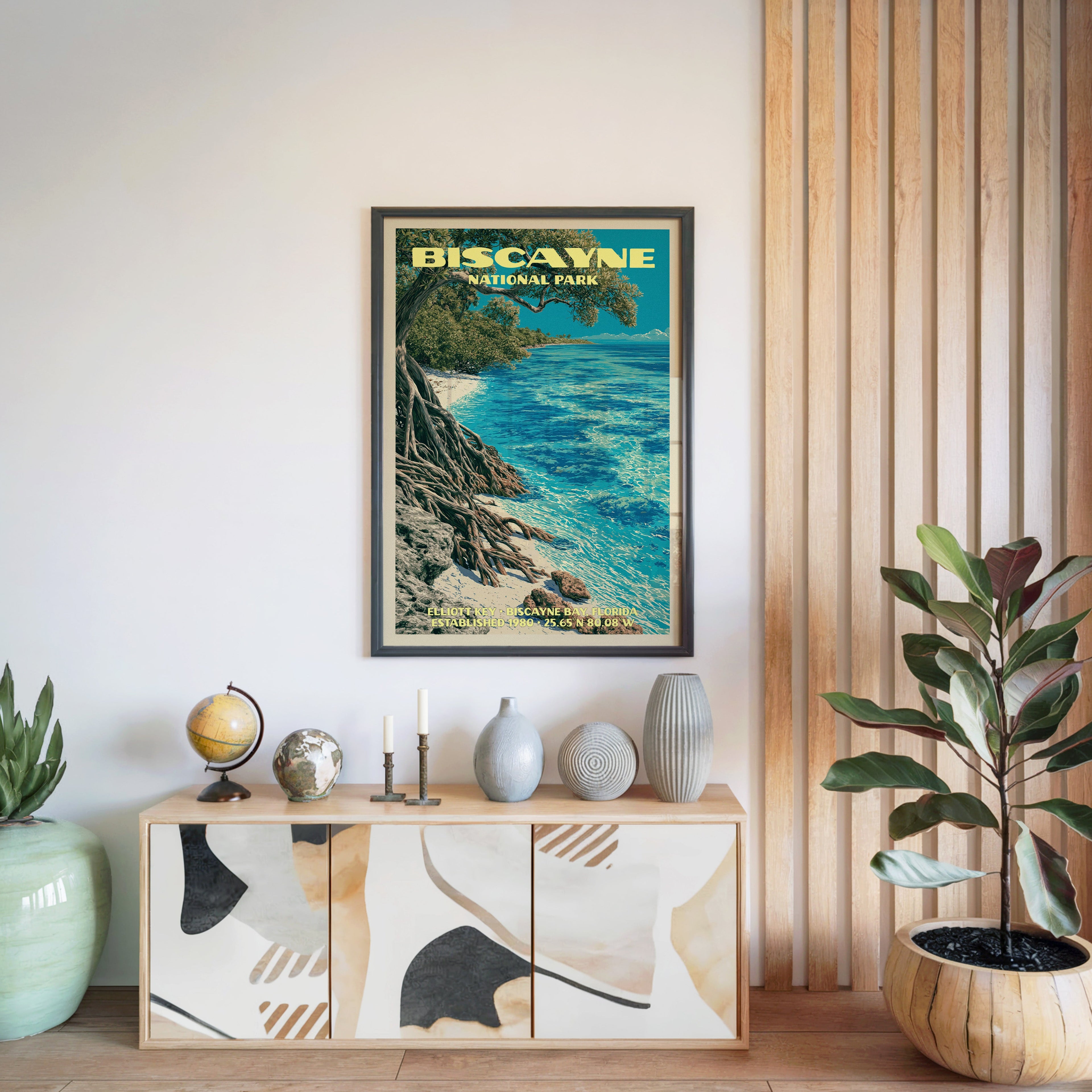 Biscayne National Park poster in a black frame above a light wood sideboard by a slatted wall panel