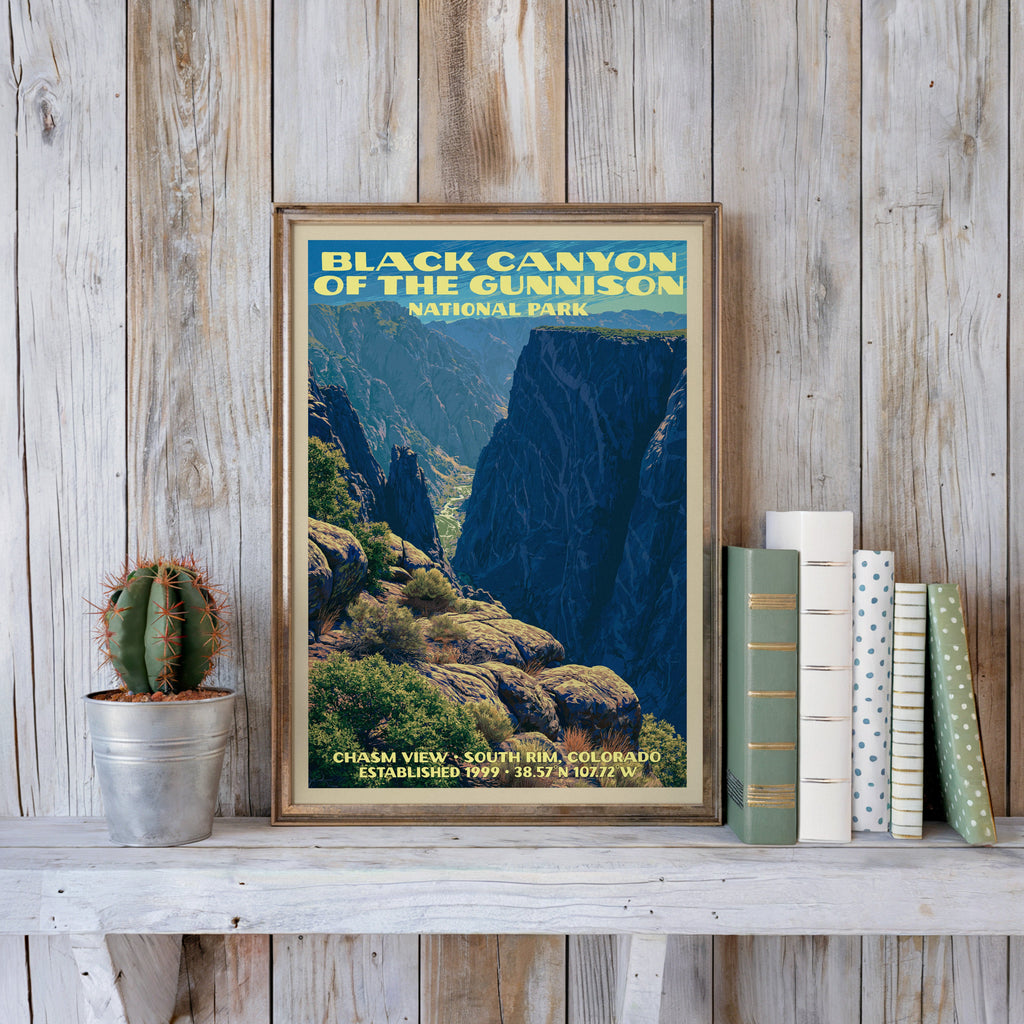 Black Canyon vintage poster in a slim gold frame on a whitewashed plank wall beside a cactus and books