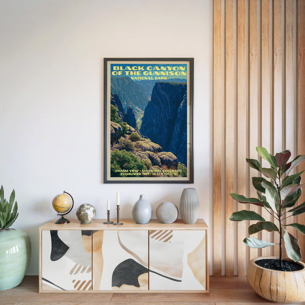 Black Canyon of the Gunnison poster in a black frame above a light wood sideboard by a slatted panel