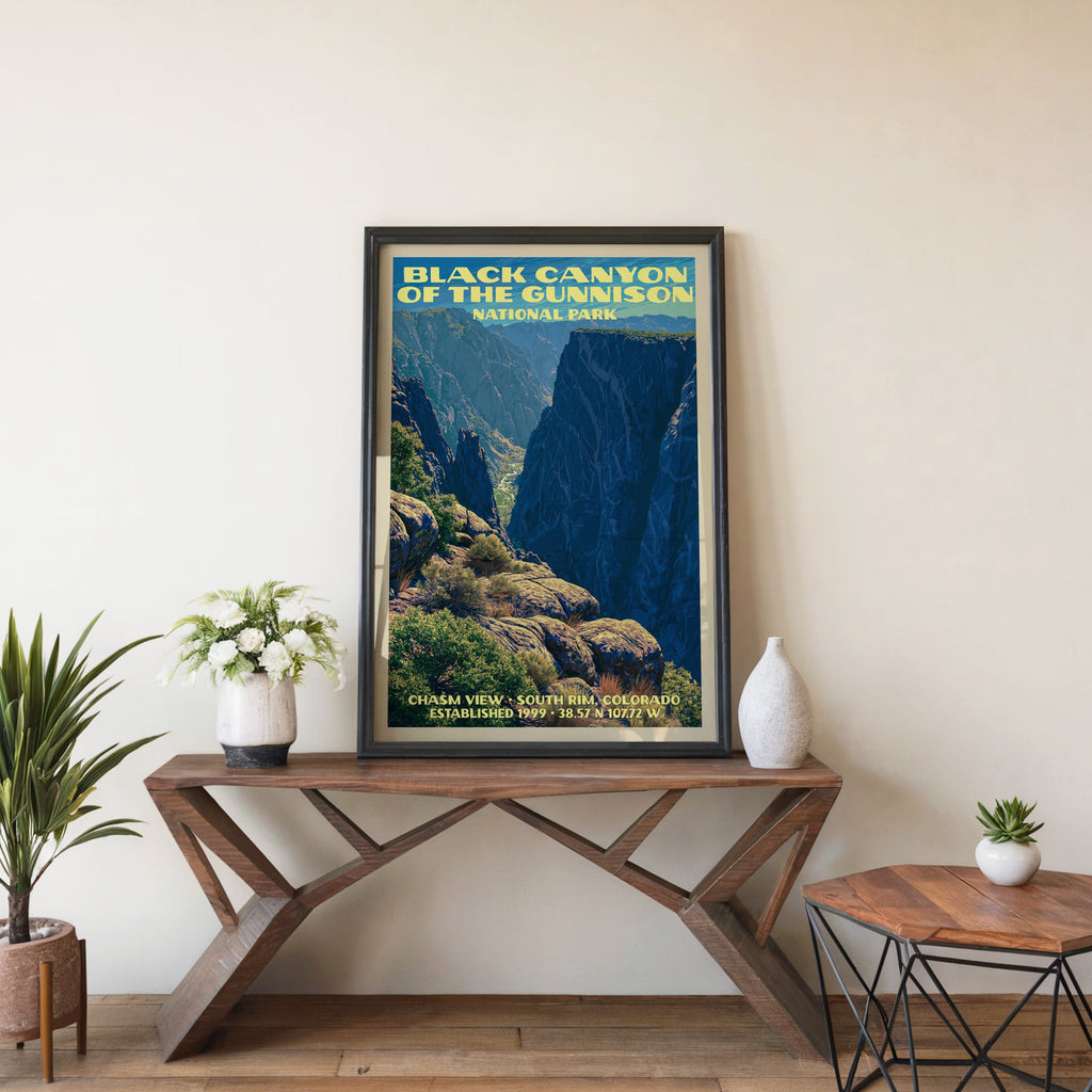 Black Canyon Chasm View wall art in black, leaning on a walnut console with white anemones and a vase
