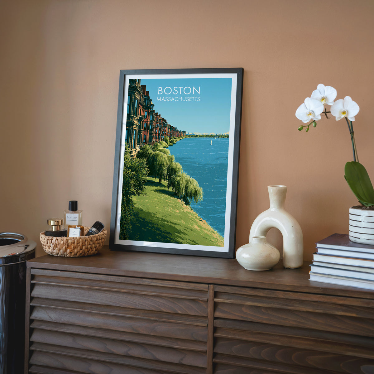 Boston Back Bay poster in a black frame on a walnut sideboard, terracotta wall, white orchid and rattan tray
