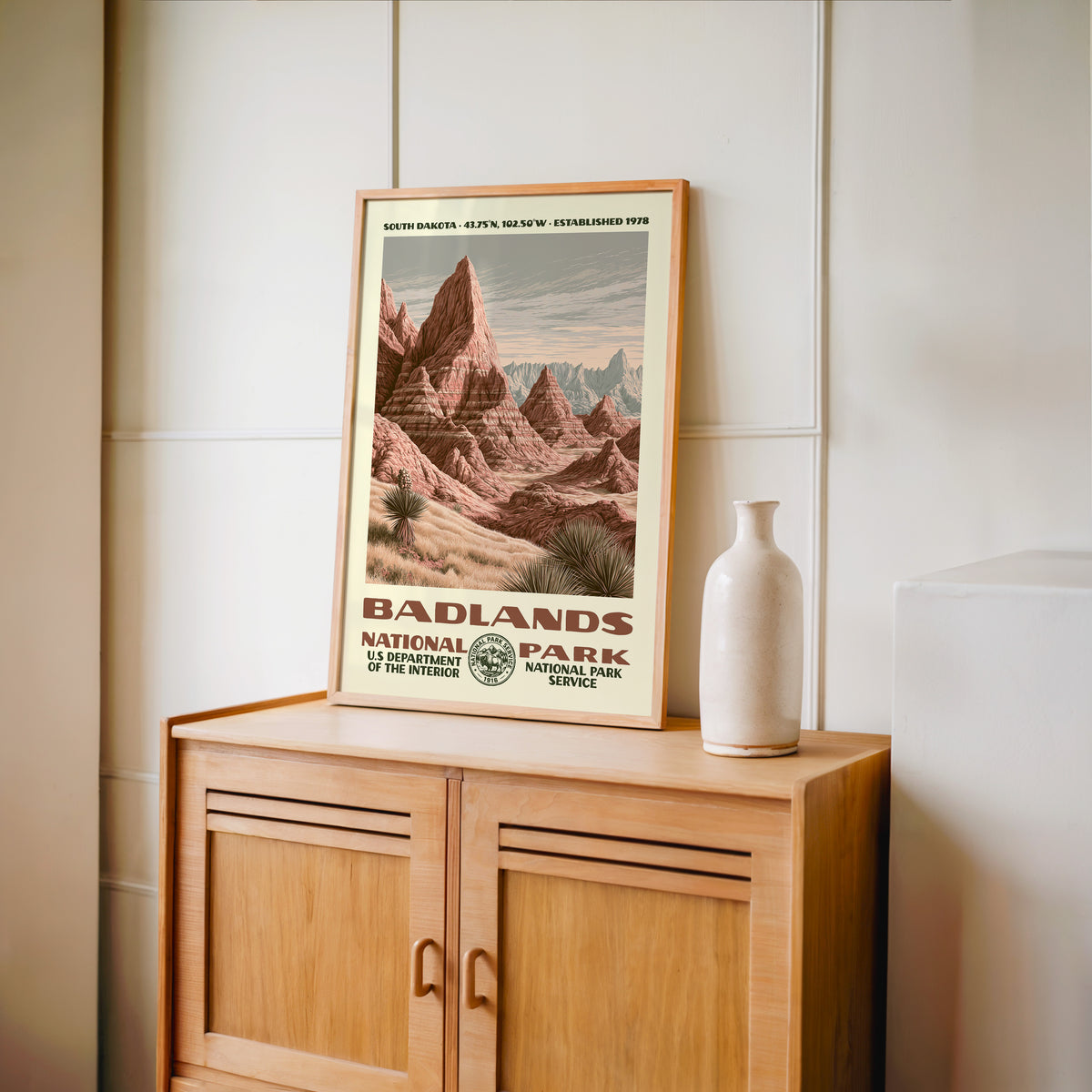 Badlands National Park WPA print framed in light oak on a wooden sideboard with a ceramic vase