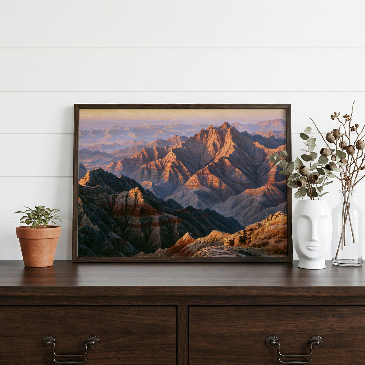 Badlands classical oil painting in a walnut frame resting on a dark wood dresser