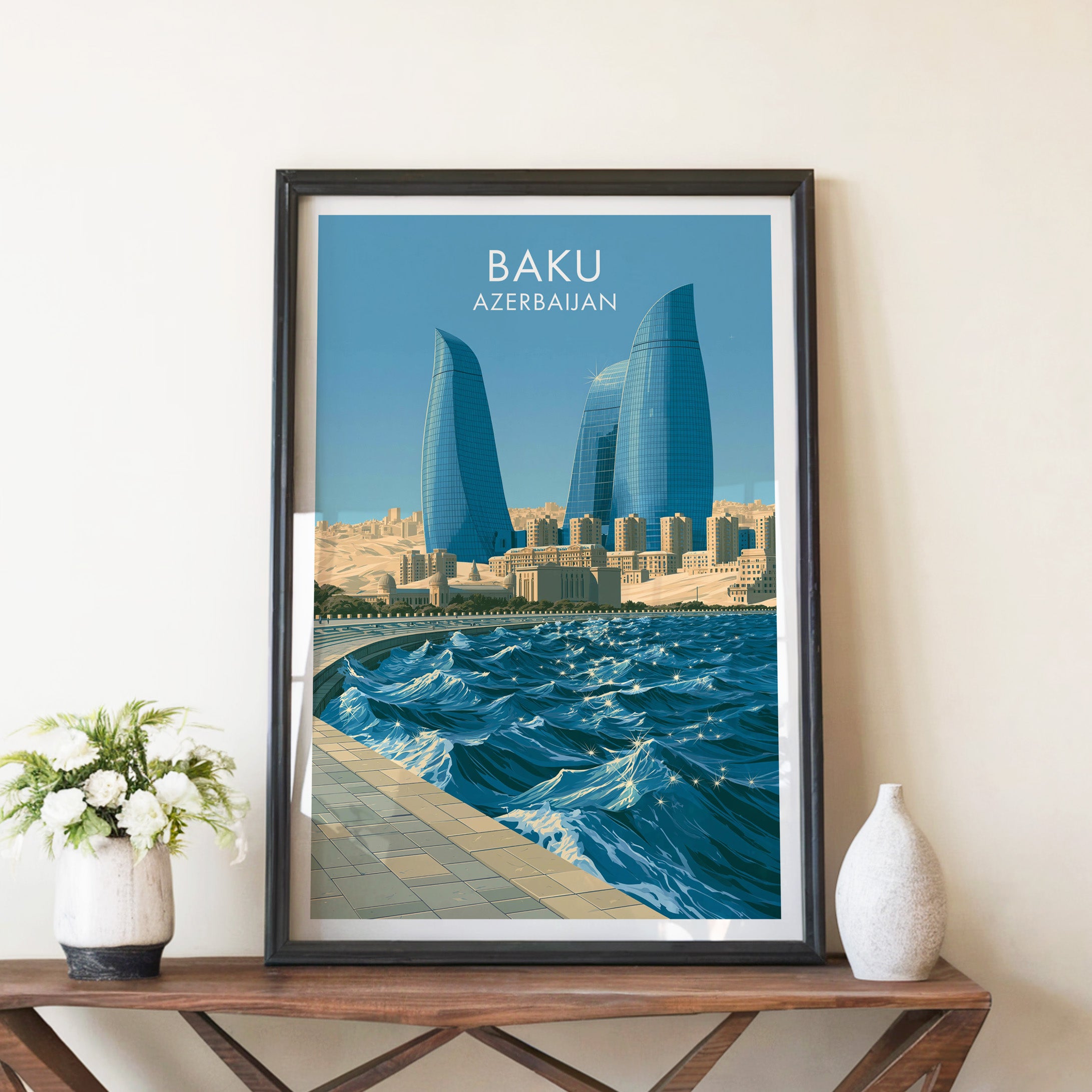 Baku Azerbaijan travel poster in a black frame on a wooden console table with white flowers