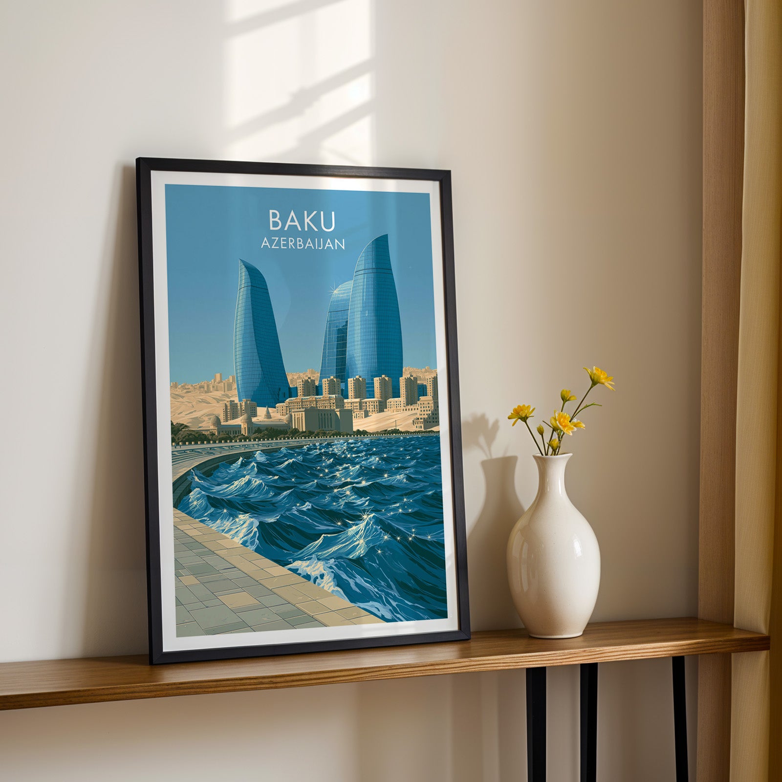 Black framed Baku Azerbaijan print on a narrow hallway console in sunlight, styled with yellow flowers