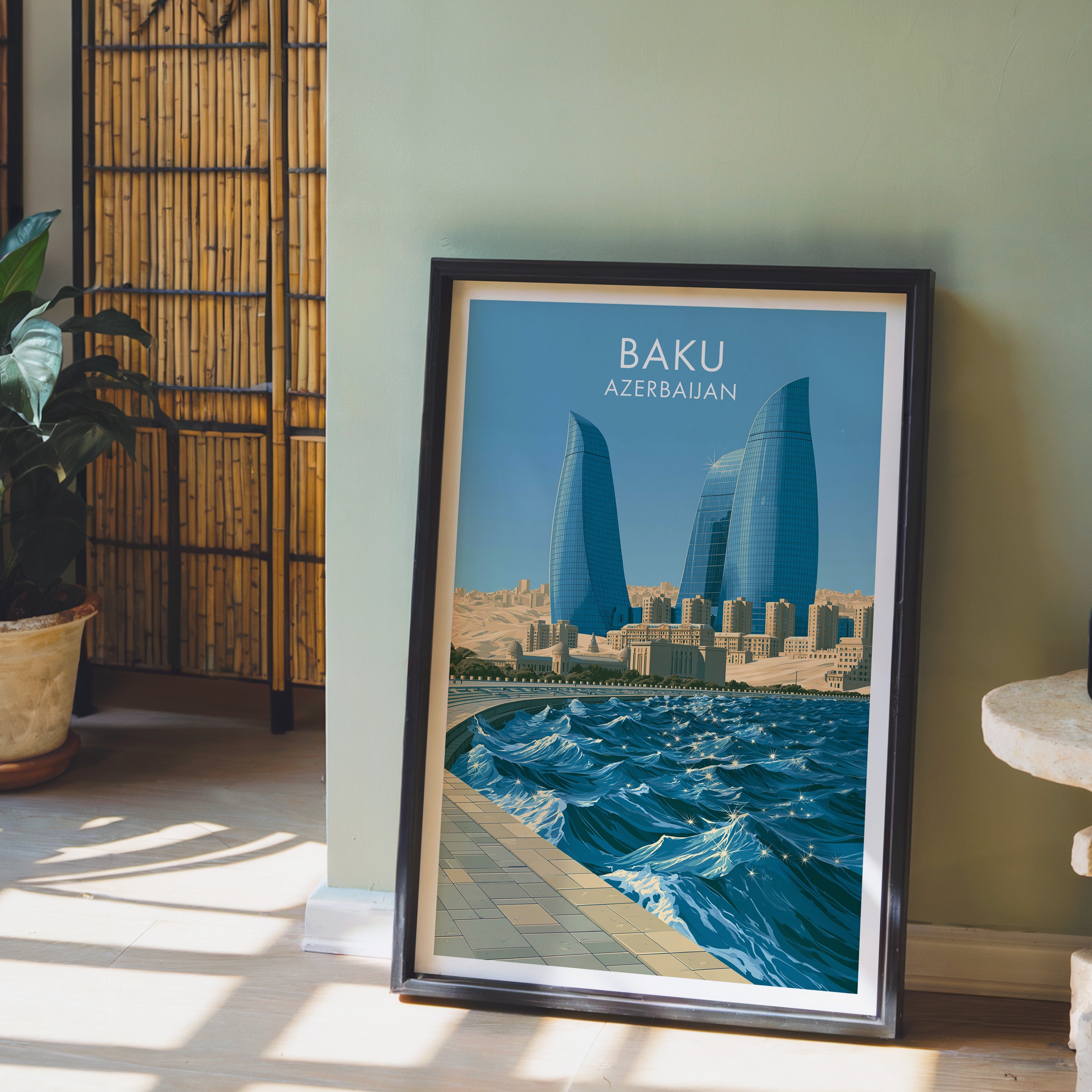 Baku Azerbaijan wall art in a black frame leaning against a sage green wall beside a bamboo screen