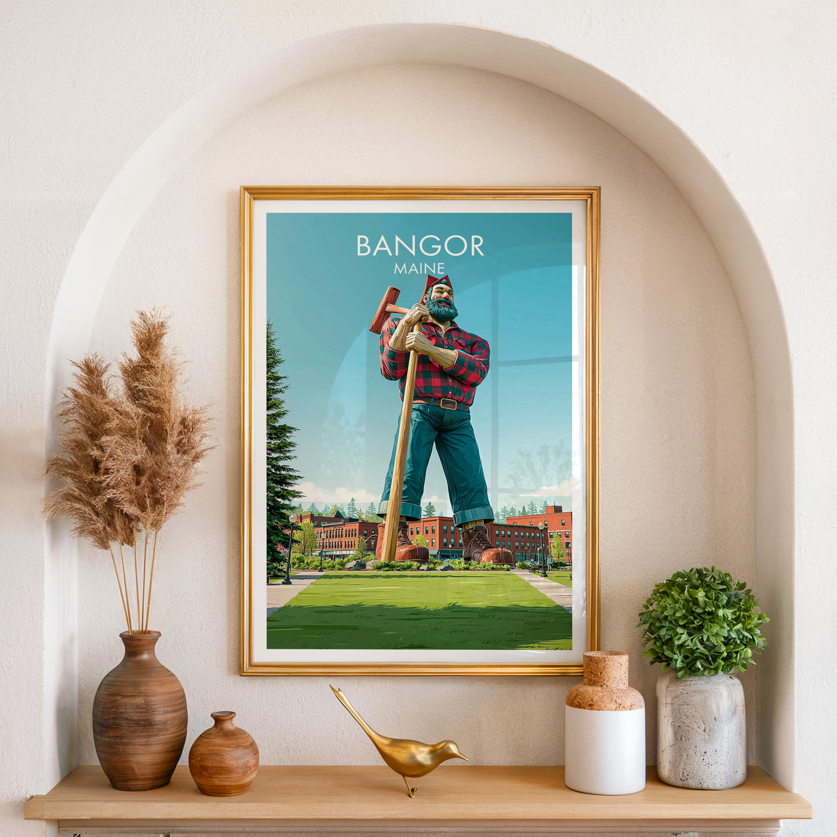Bangor Maine print in a gold frame set in an arched wall niche with pampas grass and a brass bird.