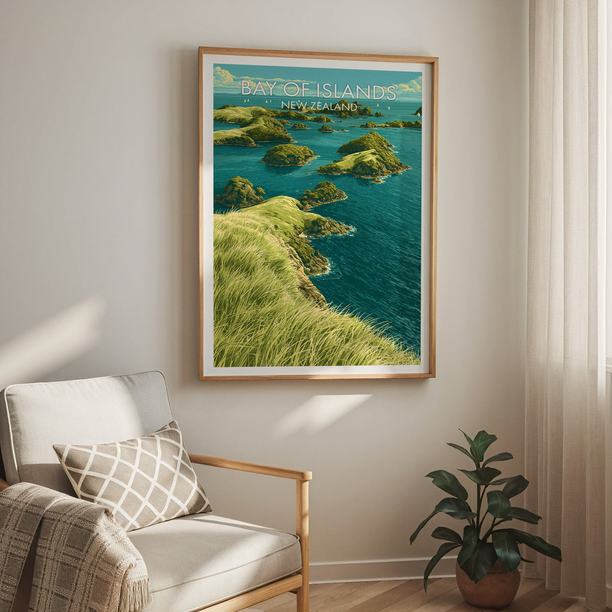 Bay of Islands print above a cream armchair with a sheer curtain and a rubber plant in terracotta