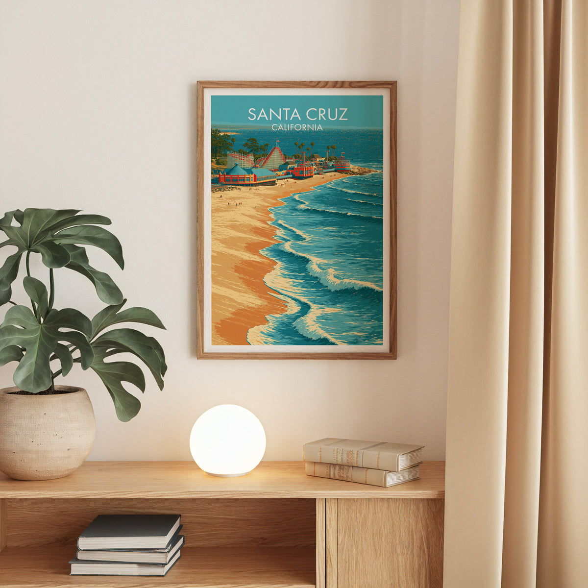 California beach poster in an oak frame on a beige wall over an oak console with a monstera