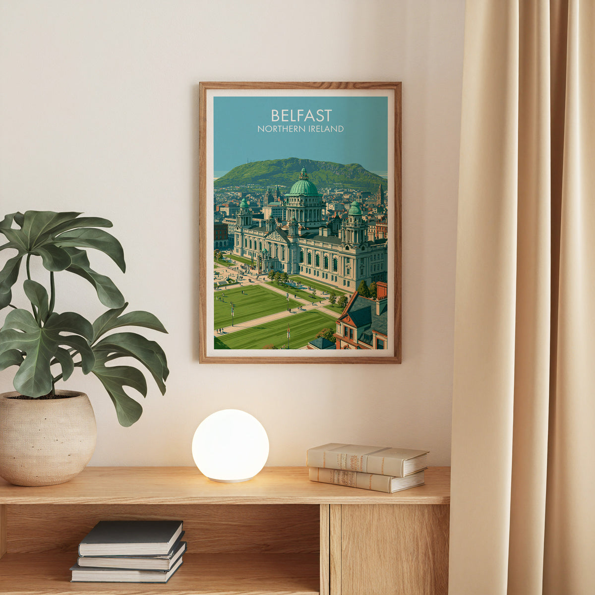 Belfast city hall print, oak frame above an oak console with a monstera and a round globe lamp