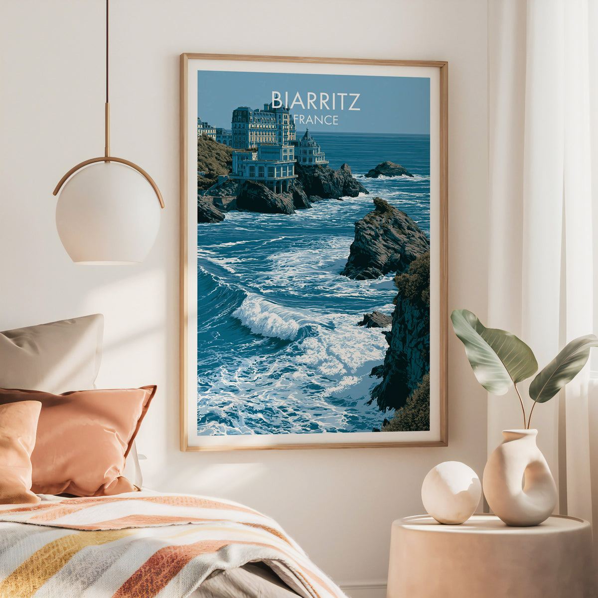 Biarritz France wall art, large oak frame above a bed with rust bedding and a brass globe pendant