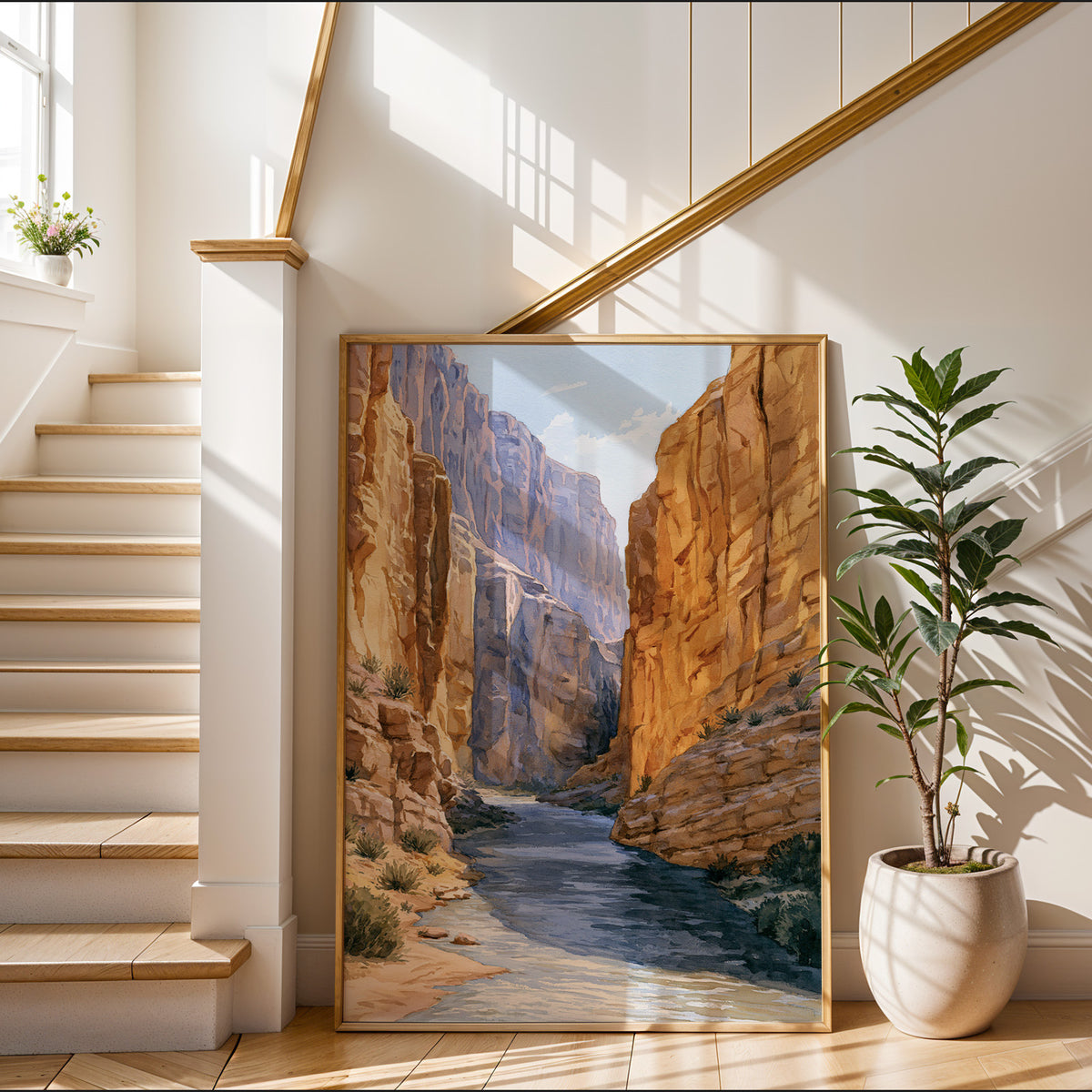 Gold-framed Big Bend National Park watercolor art print leaning in a sunlit entryway beside a staircase